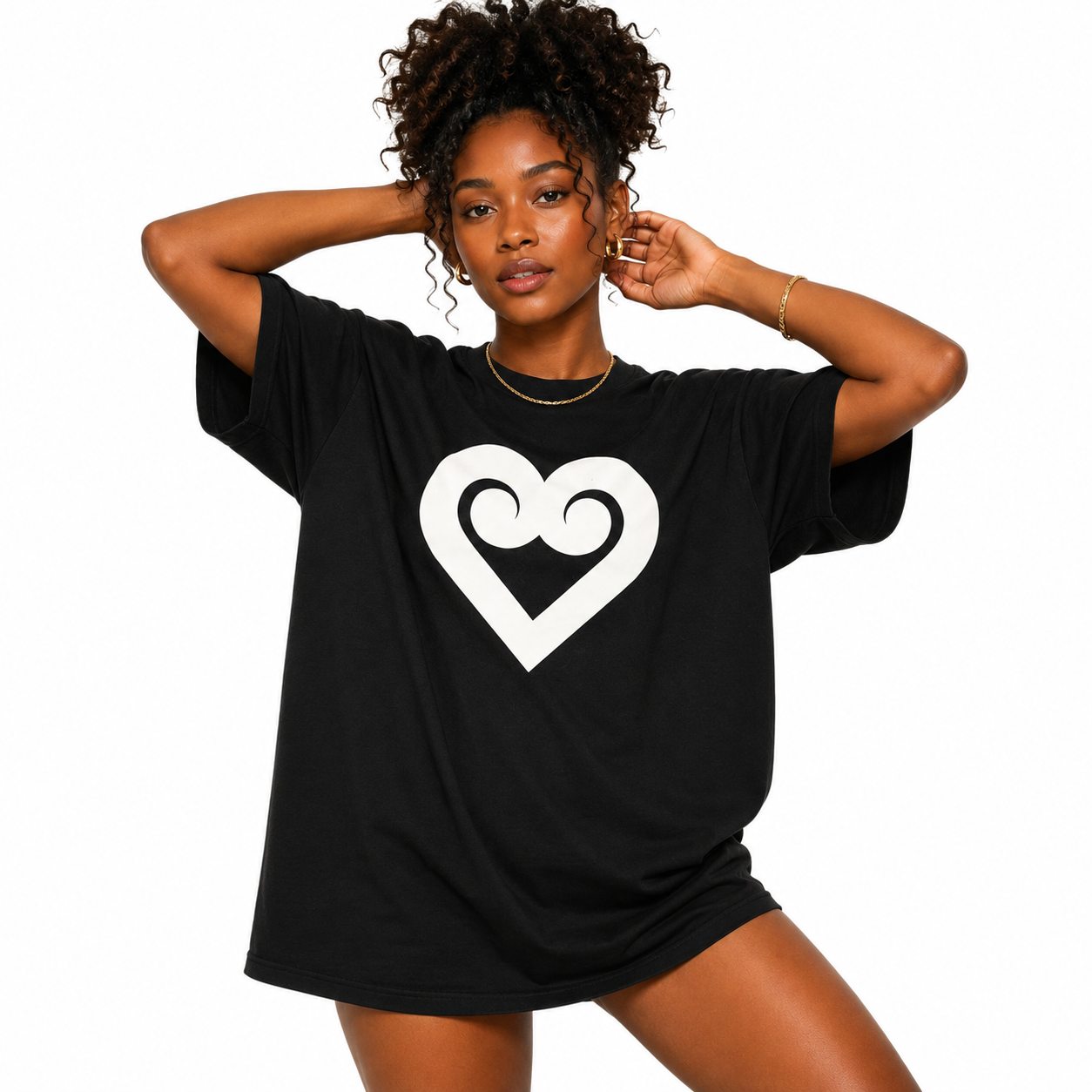 A woman modeling an oversized black t-shirt with a large white heart outline graphic on the front, set against a plain white background.
