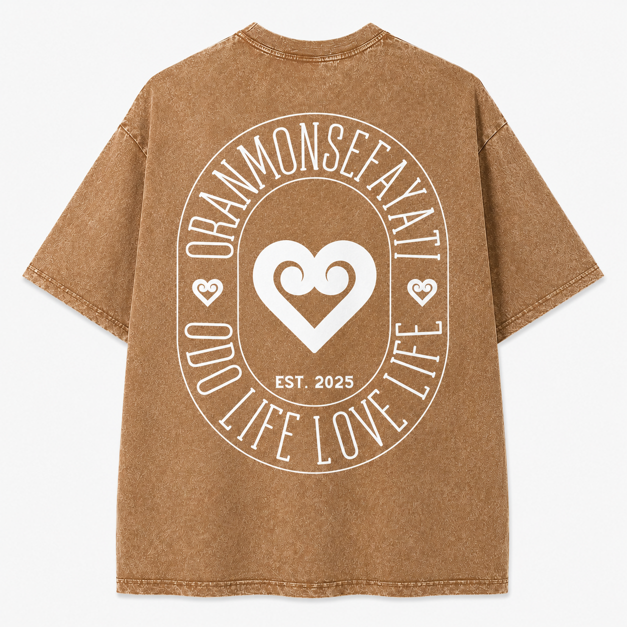 A brown mineral-wash t-shirt shown from the back, featuring a large white circular graphic with a heart in the center and the text 'ORANMONSEAYATI', 'LIFE LOVE LIFE', and 'EST. 2025'.