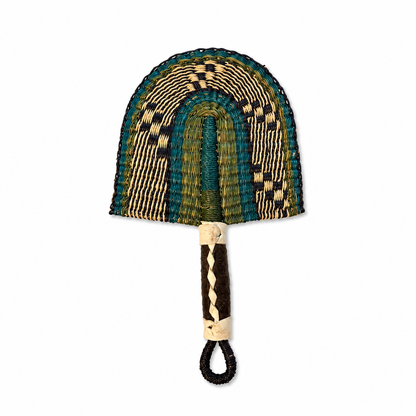 A hand-woven fan with a semi-circular woven head in green, teal, beige, and black patterns, and a dark brown wrapped handle with a cream-colored loop.
