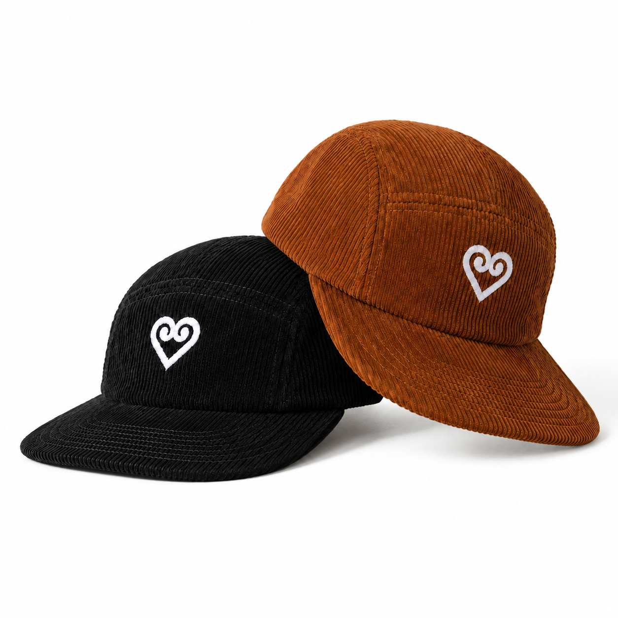 Two corduroy 5-panel cap hats, one black and one rust brown, both featuring a white embroidered heart-with-loop logo on the front, set against a plain white background.
