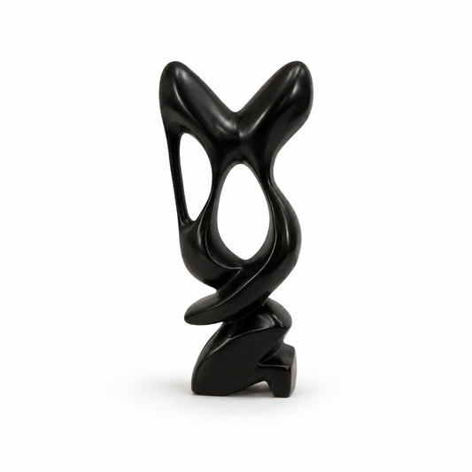 A modern abstract black sculpture with a glossy finish, featuring organic flowing shapes and hollow cutouts, standing on a small sculptural base against a plain white background.