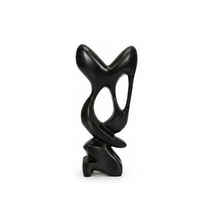 A modern abstract black sculpture with smooth curved lines and organic cutouts, standing on a small sculptural base against a plain white background.