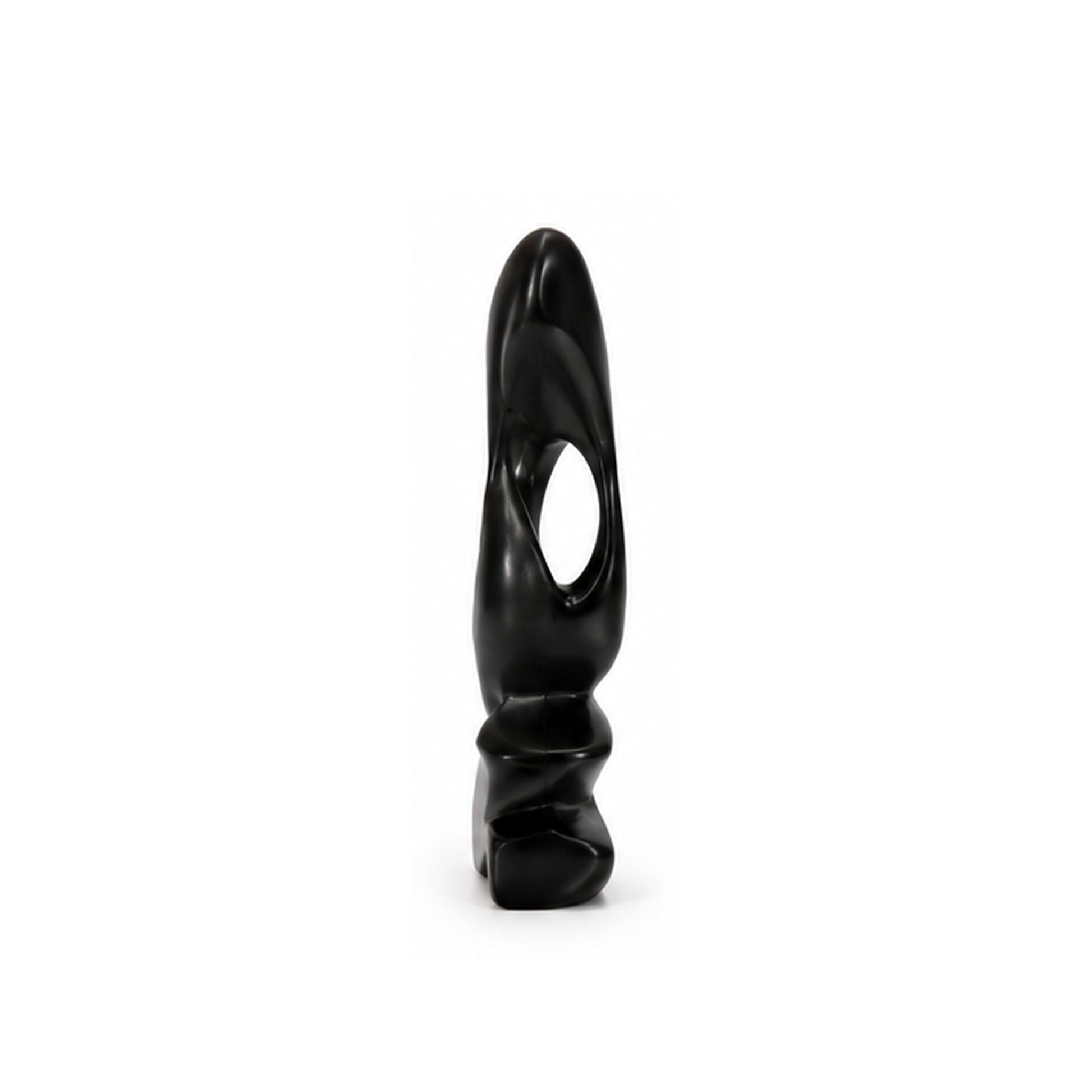 A small black sculptural object with a smooth glossy finish, featuring a curved organic shape and a central oval cutout, standing upright on a white background.