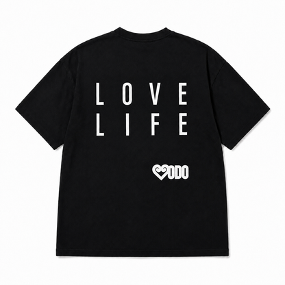 A black short-sleeve t-shirt shown from the back, featuring the words 'LOVE LIFE' printed in large white block letters and a small white heart logo with 'ODO' underneath.