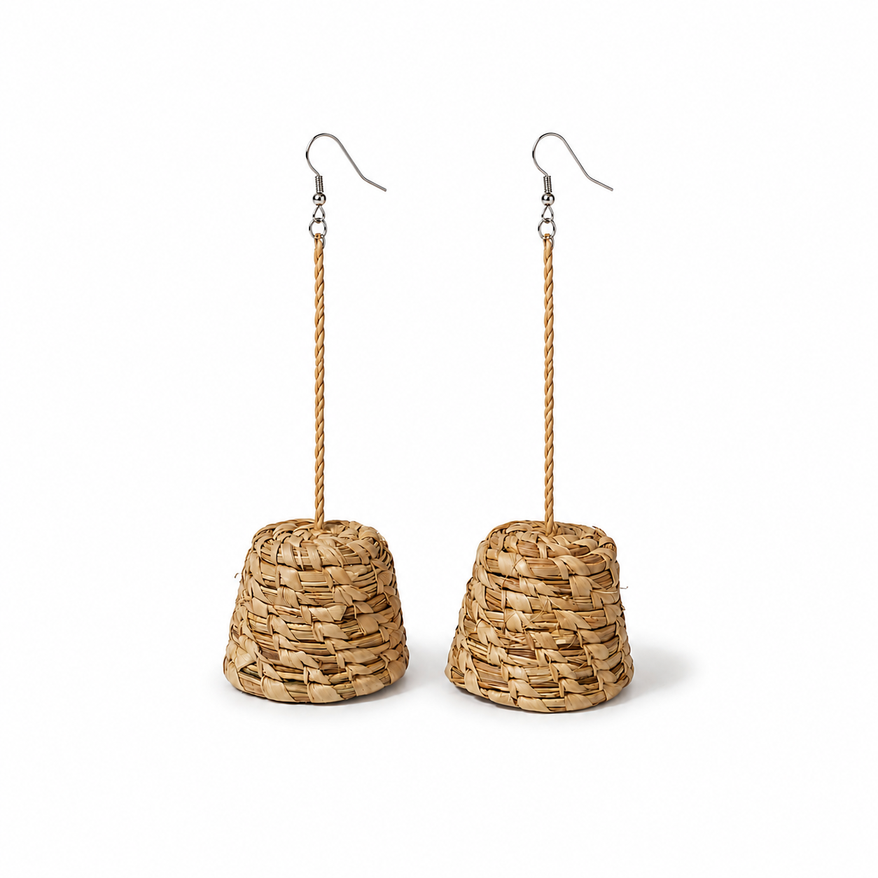 A pair of dangling earrings made from natural woven straw or seagrass in a tapered cone shape, hanging from twisted rope stems and silver fishhook ear wires, shown against a plain white background.